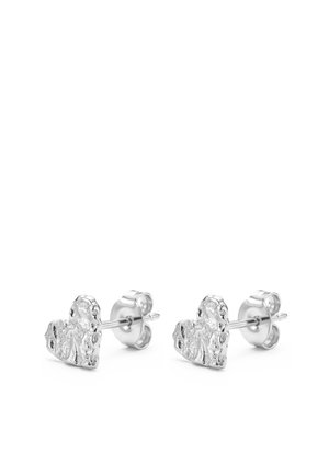 Paire de petites boucles d'oreilles clous en forme de cœur en argent avec surface texturée et fermoir papillon sur fond blanc.
