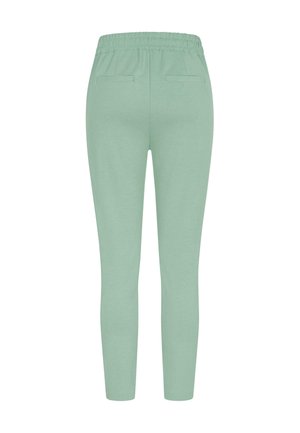 Pantaloni de trening verde mentă cu o talie elastică, croi slim și două buzunare la spate. Material moale cu o textură netedă și fără modele vizibile.