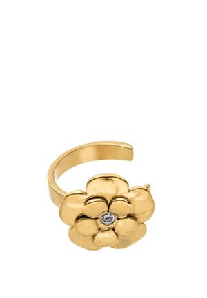 Verstellbarer goldfarbener Ring mit einem polierten Blumendesign und einem klaren Edelstein in der Mitte vor weißem Hintergrund.