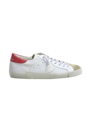 Sneaker bianca bassa con patch rosso sul tallone, punta beige, lacci bianchi e logo laterale su una suola chiara.