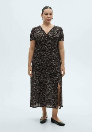 Black midi dress with short sleeves, floral print in red and yellow, V-neck design, split side, worn with black flats. Smooth, lightweight fabric.