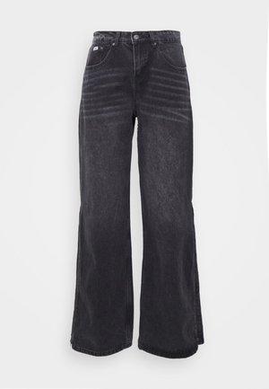 Široke črne jeans hlače z visokim pasom, ki imajo dve sprednji žepi in subtilno bledenje. Material ima mehak izgled.