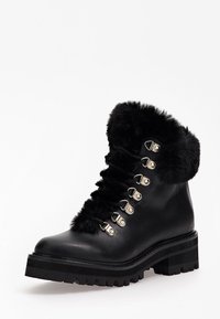 Svart läderankelboot med tjock sula, silverfärgade öglor, svarta snören och mjuk svart pälsdetalj upptill och på tungan.