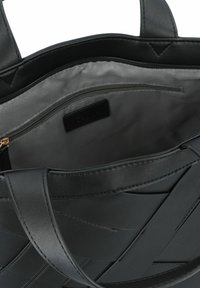 Sac à main en cuir noir avec une surface lisse et texturée ; l'intérieur présente une doublure grise et une poche zippée ; double anses.