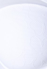White bra featuring a floral embossed pattern, smooth texture, and a transparent mesh upper band with a subtle sheen.