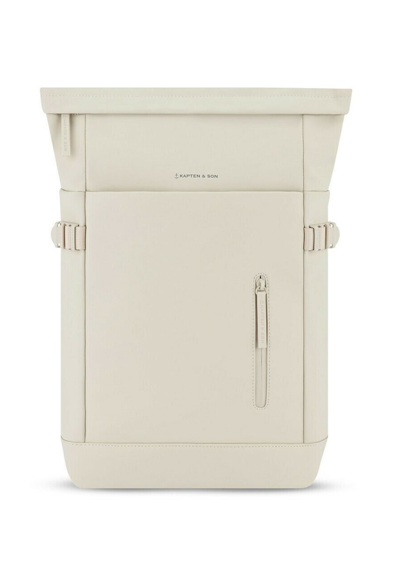 Mochila tipo roll-top en suave material color crema; cuenta con un bolsillo delantero con cremallera, hebillas laterales y un branding minimalista. Textura suave, forma estructurada.