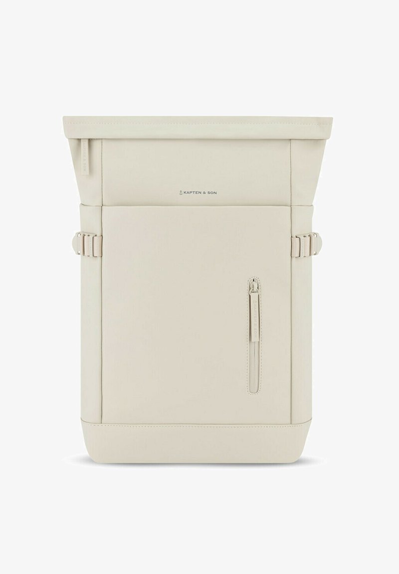 Mochila tipo roll-top en suave material color crema; cuenta con un bolsillo delantero con cremallera, hebillas laterales y un branding minimalista. Textura suave, forma estructurada.