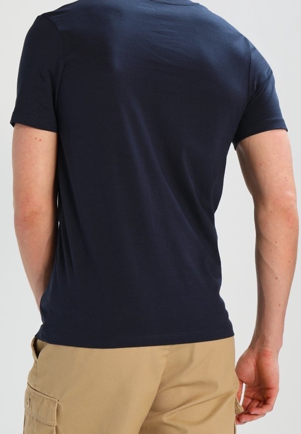 Navy blue short-sleeve T-shirt in smooth cotton fabric, featuring a plain back design and a crew neckline, worn with light-colored shorts.