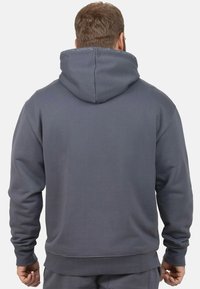 Grijze hoodie met een relaxte pasvorm, gemaakt van zachte stof; voorzien van een trekkoord in de capuchon en ribgebreide manchetten en onderkant.