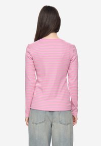 Langarmshirt, nauwsluitend, in roze met lichtgrijze horizontale strepen, gemaakt van zachte stof. Heeft een ronde halslijn en een rechte zoom.