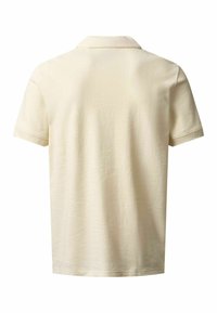 Polo à manches courtes de couleur crème uni, vu de dos, avec un col classique et un tissu doux à la texture délicate.