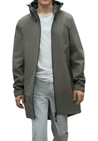 Trench gris largo con capucha, cierre de cremallera y cordones ajustables. Fabricado en un material liso e impermeable. Detalle de marca sutil.