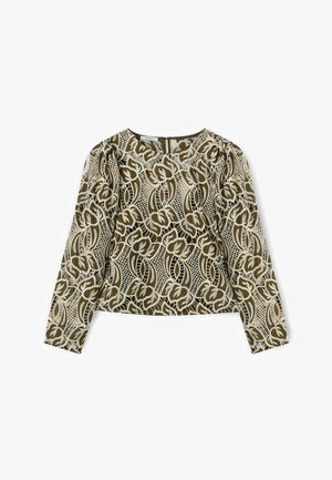 Blusa beige de manga larga con superposición de encaje de flores y celosía en verde oliva, escote redondo y cierre con cremallera en la espalda.