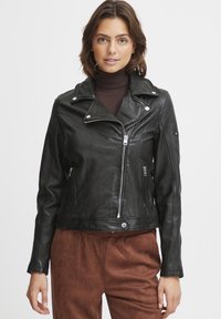 Black leather motorcycle jacket with zip fastening, asymmetrical design, silver hardware accents, and a fitted silhouette.