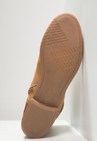 Braune Wildleder-Ankle-Boots mit Gummisohle, die ein strukturiertes Muster und die Marke "s.Oliver." zeigt. Größe 37 deutlich auf der Sohle sichtbar.