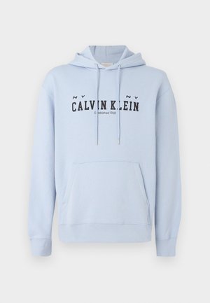 Világoskék kapucnis pulóver, amely anyagból készült, elülső zsebbel, nyúlós húzózsinórral, és fekete nyomott felirattal: "CALVIN KLEIN Established 1968" elől.