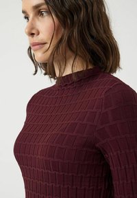 Bordowy prążkowany sweter z wysokim dekoltem i teksturowanym wzorem kwadratów, dopasowany krój oraz minimalna liczba szwów.