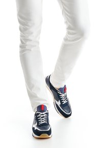 Marineblaue Laufschuhe aus Mesh- und Wildledermaterial; weiße Akzente; rote und blaue Details; Gummisohle; Schnürsenkel und gepolstered Zunge.