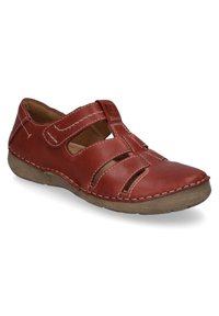 Red leather shoe with cutouts and Velcro straps, featuring contrasting light stitching and a textured beige sole.