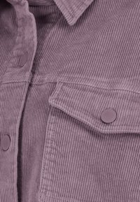 Paarse corduroy shirt met een textuurafwerking, met een kraag, twee klepzakken en ronde knopen voor sluiting. Verticale ribbelpatroon.