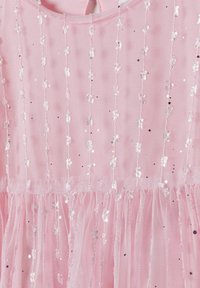 Robe en mesh rose avec des lanières verticales de sequins, un tissu texturé, et un bas voluminé, créant un effet superposé.
