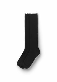 Schwarze, kniehohe Socken mit glatter Textur, hergestellt aus einem weichen Stoff, mit verstärkten Fersen und Zehen für zusätzliche Haltbarkeit. Drei Paare sind ausgestellt.