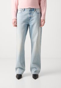 Light blue wide-leg jeans made of denim, featuring a faded appearance and a five-pocket design, paired with black pointed-toe heels.