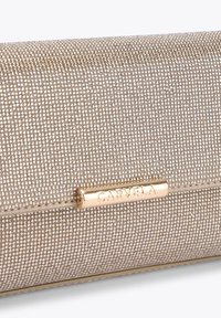 Clutch tono oro con superficie testurizzata di piccoli rivetti metallici, dotata di una placca del marchio metallica, dalla forma rettangolare elegante.