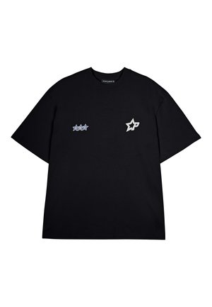 T-shirt nera in cotone con due toppe ricamate: un design a forma di stella blu e una stella argentata con iniziali, maniche corte, vestibilità rilassata.
