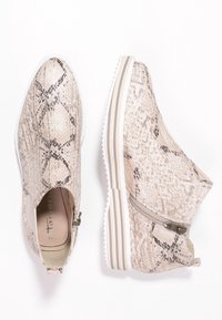 Sneakers con un design a stampa pitonata beige, chiusura a zip su un lato, suola a strisce bianche e grigie, e texture liscia.