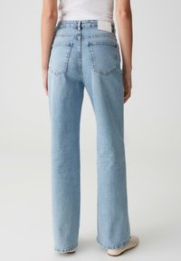 Light blue wide-leg jeans made of denim, featuring a high waist, back pockets, and a white tag on the waistband.