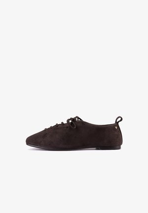 Zapato plano de ante marrón oscuro con cordones, puntera redondeada y lengüeta en el talón, mostrado de lado sobre fondo blanco.