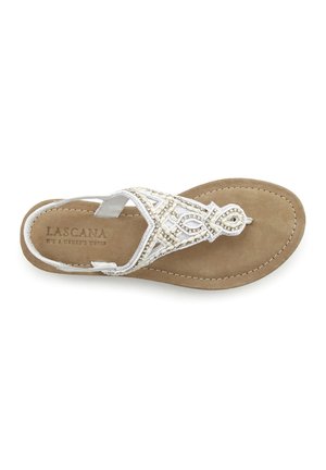 Sandali piatti con una soletta in suede beige, cinturini in tessuto bianco e perline decorative disposte in un motivo geometrico sulla parte superiore.