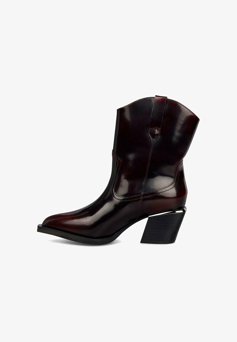Bota de cowboy de punta afilada en cuero burdeos oscuro. Presenta un tacón en bloque angulado alto y detalles de costura vertical; acabado suave y brillante.