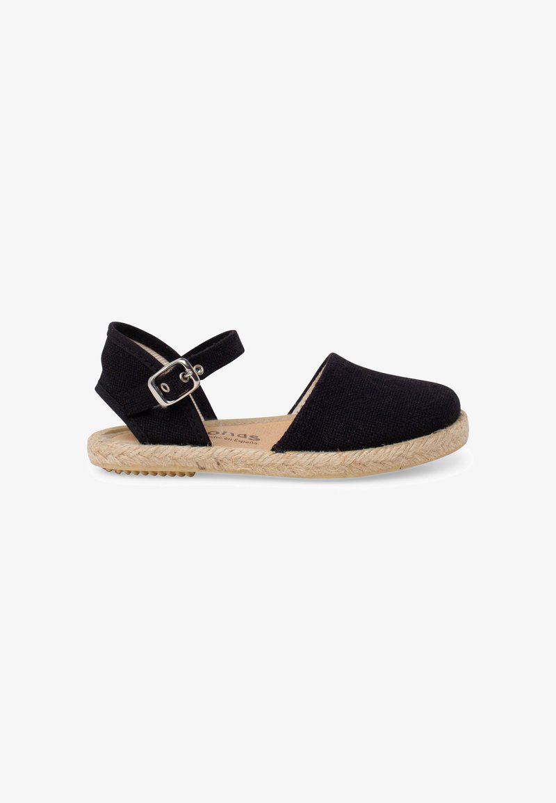 Chaussure plate espadrille noire avec bout fermé, côtés ouverts, bride de cheville avec boucle argentée et semelle en corde naturelle.