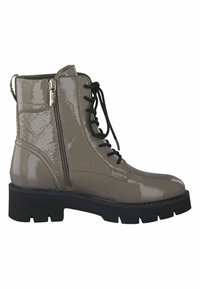 Botines de charol beige hasta el tobillo con cordones en la parte delantera, cremallera lateral y suela de goma negra gruesa. Presentan un acabado suave y brillante.