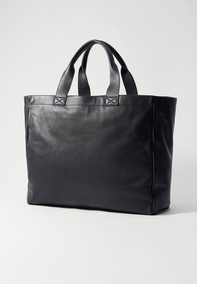 Sac à main en cuir noir avec deux poignées supérieures, forme rectangulaire, surface texturée et sans matériel ou accents visibles.
