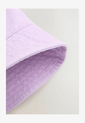 Svijetlocrvena tkanina s teksturiranom, rebrastom površinom. Rub je uredno dovršen, s vidljivim šavom duž poruba.