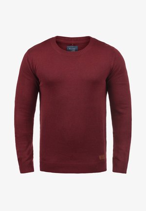 Burgundski pletene pulover s okroglo izrezom, dolgimi rokavi, rebrastimi manšeti in robom ter majhno blagovno znamko na spodnji strani.