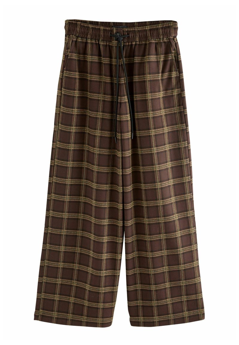 Pantalon marron ample avec motif à carreaux jaunes et taille élastique avec cordon noir à l'avant.