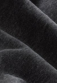 Schwarzer Stoff mit einer weichen, strukturierten Oberfläche, die ein dezentes diagonales Webmuster aufweist und glatt sowie leicht reflektierend wirkt.