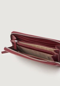 Cartera de cuero rojo oscuro con cierre de cremallera, múltiples ranuras para tarjetas y un forro interior suave. Exterior texturizado con acentos de hardware plateado.