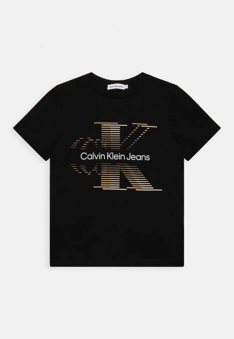 Camiseta negra de manga corta hecha de algodón, con un logo "CK" estilizado en dorado y blanco y el texto "Calvin Klein Jeans" en la parte delantera.