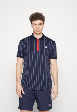 Marine gestreept polo shirt met rode knopen en kraag; heeft een klein logo op de borst en een slim fit ontwerp. Gecombineerd met marineblauwe shorts.