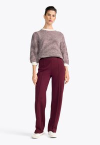 Sweter w paski w kolorze burgundowym i kremowym, z okrągłym dekoltem i rękawami 3/4. Połączony z spodniami w kolorze bordowym o wysokim stanie.