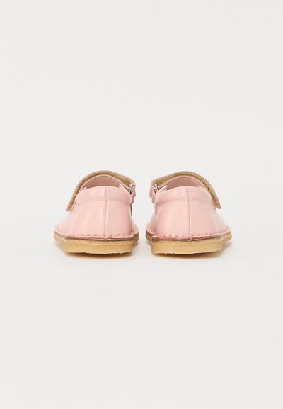 Rosa lær sko med en rund form, brune såler og borrelåsremmer. Jevn tekstur med en sydd design langs kantene.