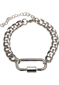 Bracelet en chaîne de métal argenté avec un grand fermoir, présentant des maillons interconnectés et une chaîne ajustable pour variation de taille.