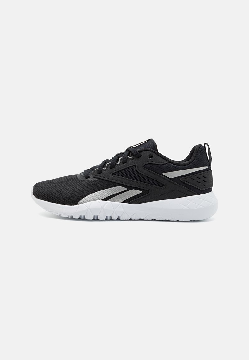Chaussure de sport noire avec semelle blanche et accents argentés, dessus en mesh, design à lacets et semelle extérieure texturée, vue de profil.