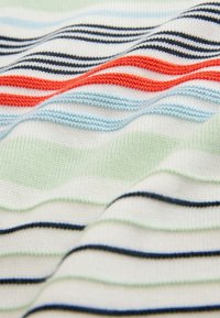 Tissu tricoté doux avec des rayures horizontales en noir, rouge, bleu clair et vert clair sur fond blanc, montrant la texture et les plis.