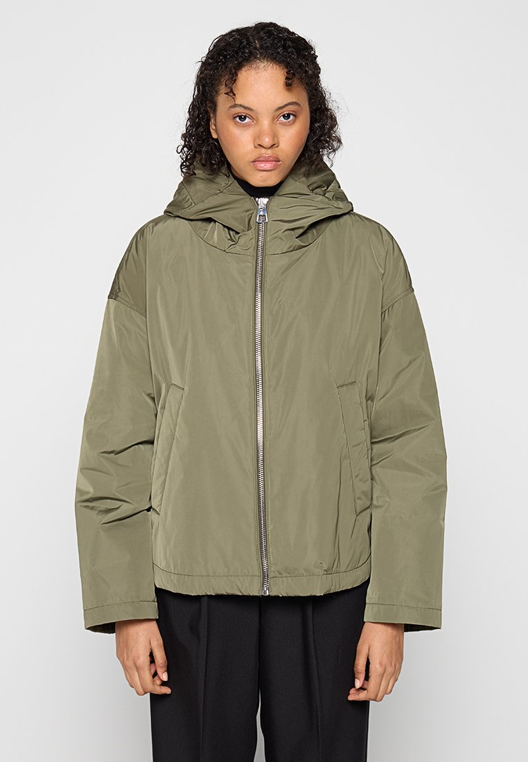 Olivgrüne Steppjacke mit Kapuze, frontalem Reißverschluss, Seitentaschen und lässiger Passform. Glatte Textur und leichtes Design.